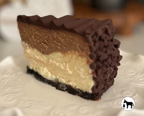 Layered chocolate and vanilla mousse cake on a decorative plate.